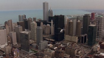 Movie still from “The Fugitive” (1993), directed by Andrew Davis – An aerial view of a large city with skyscrapers; Extreme Wide shot, High angle