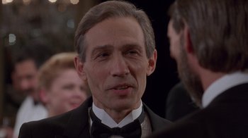 Movie still from “The Fugitive” (1993), directed by Andrew Davis – A person wearing a suit and a bow tie; Close Up shot, Over the shoulder angle