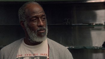 Movie still from “The Fugitive” (1993), directed by Andrew Davis – An older black man with a beard looking to his left; Close Up shot, Low angle