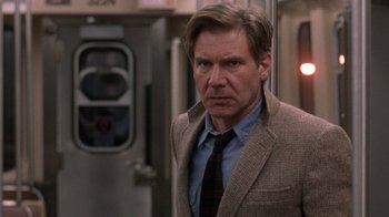 Movie still from “The Fugitive” (1993), directed by Andrew Davis – A person wearing a suit and tie; Close Up shot, Low angle