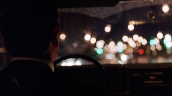 Movie still from “The Fugitive” (1993), directed by Andrew Davis – A man driving a car at night in the dark; Close Up shot, Over the shoulder angle