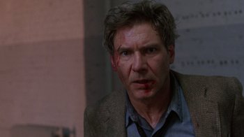 Movie still from “The Fugitive” (1993), directed by Andrew Davis – A man with blood on his face is looking at the camera; Close Up shot, Low angle