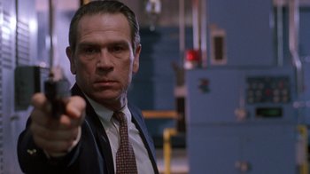 Movie still from “The Fugitive” (1993), directed by Andrew Davis – A man in a suit and tie pointing at the camera; Close Up shot, Low angle