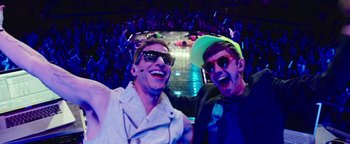 Movie still from “Popstar: Never Stop Never Stopping” (2016), directed by Akiva Schaffer – A couple of people that are in a room with lights on; Medium shot, High angle