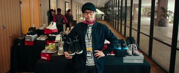 Movie still from “Popstar: Never Stop Never Stopping” (2016), directed by Akiva Schaffer – A man holding a pair of shoes in his hands; Medium shot, Over the shoulder angle