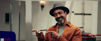 Movie still from “Popstar: Never Stop Never Stopping” (2016), directed by Akiva Schaffer – An older man wearing a hat pointing to the side; Medium shot, Low angle