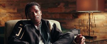 Movie still from “Popstar: Never Stop Never Stopping” (2016), directed by Akiva Schaffer – A person sitting in a chair wearing a jacket; Close Up shot, Over the shoulder angle