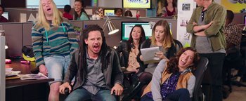 Movie still from “Popstar: Never Stop Never Stopping” (2016), directed by Akiva Schaffer – A group of people sitting in a room; Medium shot, Over the shoulder angle