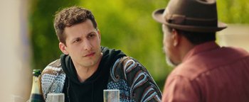 Movie still from “Popstar: Never Stop Never Stopping” (2016), directed by Akiva Schaffer – A man sitting next to another man in a hat; Close Up shot, Over the shoulder angle