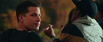 Movie still from “Popstar: Never Stop Never Stopping” (2016), directed by Akiva Schaffer – A person wearing a suit and tie; Close Up shot, Over the shoulder angle