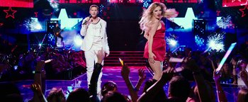 Movie still from “Popstar: Never Stop Never Stopping” (2016), directed by Akiva Schaffer – A man and a woman performing on a stage; Wide shot, Low angle