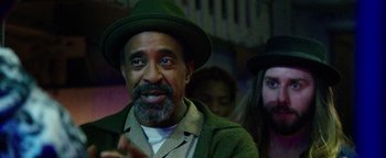 Movie still from “Popstar: Never Stop Never Stopping” (2016), directed by Akiva Schaffer – A man with a beard and a green hat is smiling; Close Up shot, Over the shoulder angle