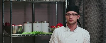 Movie still from “Popstar: Never Stop Never Stopping” (2016), directed by Akiva Schaffer – A man wearing a chef's hat in a kitchen; Close Up shot, Over the shoulder angle