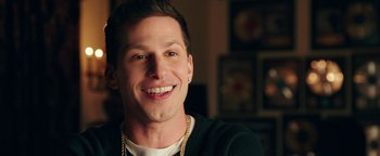 Movie still from “Popstar: Never Stop Never Stopping” (2016), directed by Akiva Schaffer – A person wearing a necklace; Close Up shot, Over the shoulder angle
