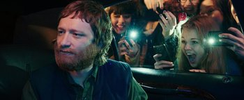 Movie still from “Popstar: Never Stop Never Stopping” (2016), directed by Akiva Schaffer – A group of people taking pictures in a car mirror; Close Up shot, Over the shoulder angle