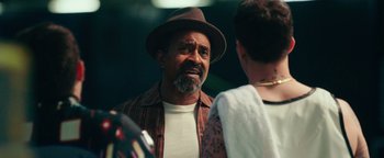 Movie still from “Popstar: Never Stop Never Stopping” (2016), directed by Akiva Schaffer – A man with a beard and a hat talking to a woman; Close Up shot, Over the shoulder angle