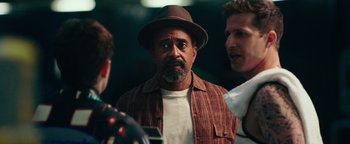 Movie still from “Popstar: Never Stop Never Stopping” (2016), directed by Akiva Schaffer – A group of men standing next to each other in a room; Close Up shot, Over the shoulder angle