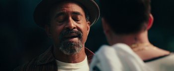 Movie still from “Popstar: Never Stop Never Stopping” (2016), directed by Akiva Schaffer – An older man wearing a hat and a plaid shirt; Close Up shot, Over the shoulder angle