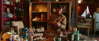 Movie still from “Popstar: Never Stop Never Stopping” (2016), directed by Akiva Schaffer – A man in an apron working in a workshop; Medium shot, High angle