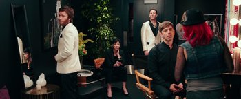 Movie still from “Popstar: Never Stop Never Stopping” (2016), directed by Akiva Schaffer – A group of people sitting in a room; Medium shot, Over the shoulder angle