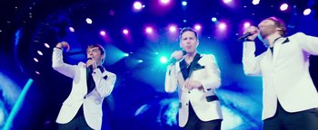 Movie still from “Popstar: Never Stop Never Stopping” (2016), directed by Akiva Schaffer – A couple of men are singing on a stage; Medium shot, Low angle
