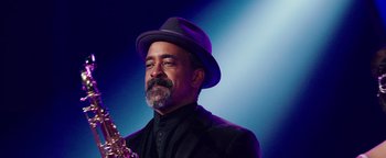 Movie still from “Popstar: Never Stop Never Stopping” (2016), directed by Akiva Schaffer – A man in a hat is holding an instrument; Close Up shot, Low angle