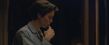 Movie still from “The Gift” (2015), directed by Joel Edgerton – A woman is holding a pen in her mouth; Close Up shot, Over the shoulder angle