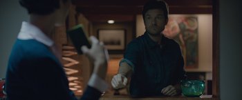 Movie still from “The Gift” (2015), directed by Joel Edgerton – A man sitting in front of another man holding a cell phone; Medium shot, Over the shoulder angle