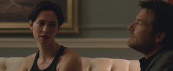 Movie still from “The Gift” (2015), directed by Joel Edgerton – A woman sitting on top of a couch in a living room; Close Up shot, Over the shoulder angle