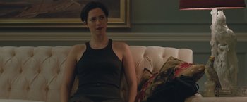 Movie still from “The Gift” (2015), directed by Joel Edgerton – A woman sitting on top of a couch in a living room; Medium shot, Over the shoulder angle