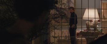 Movie still from “The Gift” (2015), directed by Joel Edgerton – A man standing in front of a window with his hands in his pockets; Wide shot, Over the shoulder angle