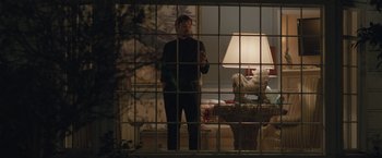 Movie still from “The Gift” (2015), directed by Joel Edgerton – A man standing in front of a window looking out; Wide shot, Low angle