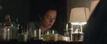 Movie still from “The Gift” (2015), directed by Joel Edgerton – A woman sitting in front of a table with candles; Close Up shot, Low angle