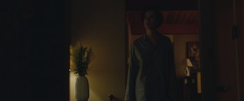 Movie still from “The Gift” (2015), directed by Joel Edgerton – A man standing next to a plant in a room; Medium shot, Low angle