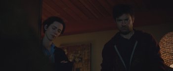 Movie still from “The Gift” (2015), directed by Joel Edgerton – Two men standing next to each other in front of a painting; Medium shot, Low angle