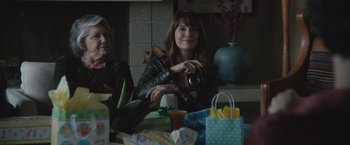 Movie still from “The Gift” (2015), directed by Joel Edgerton – Two women sitting at a table with a camera; Medium shot, Over the shoulder angle