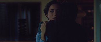 Movie still from “The Gift” (2015), directed by Joel Edgerton – A woman is hugging another woman in a dark room; Close Up shot, Over the shoulder angle