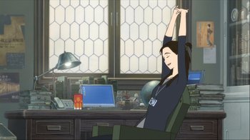 Movie still from “The Girl Who Leapt Through Time” (2006), directed by Mamoru Hosoda – A woman sitting at a desk stretching her arms; Wide shot, High angle
