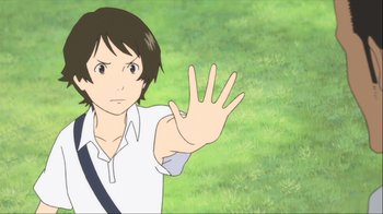 Movie still from “The Girl Who Leapt Through Time” (2006), directed by Mamoru Hosoda – A young man holding up his hand in front of a grassy area; Close Up shot, Over the shoulder angle