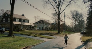 Movie still from “The Girl on the Train” (2016), directed by Tate Taylor – A woman running down the middle of the street; Extreme Wide shot, High angle