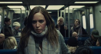 Movie still from “The Girl on the Train” (2016), directed by Tate Taylor – A woman with a scarf is standing on a train; Close Up shot, Over the shoulder angle
