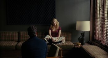 Movie still from “The Girl on the Train” (2016), directed by Tate Taylor – A woman sitting on top of a couch in front of a man; Wide shot, Over the shoulder angle