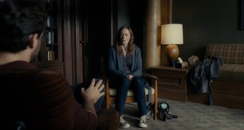 Movie still from “The Girl on the Train” (2016), directed by Tate Taylor – A woman sitting on a chair in a room; Medium shot, Over the shoulder angle