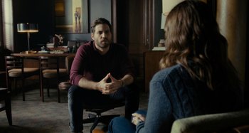 Movie still from “The Girl on the Train” (2016), directed by Tate Taylor – A man and a woman are sitting in a room; Medium shot, Over the shoulder angle