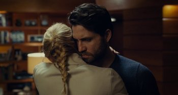 Movie still from “The Girl on the Train” (2016), directed by Tate Taylor – A man and a woman hugging each other in front of a wall; Close Up shot, Over the shoulder angle