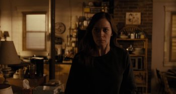 Movie still from “The Girl on the Train” (2016), directed by Tate Taylor – A woman standing in a room with a kitchen in the background; Medium shot, Over the shoulder angle