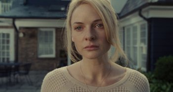 Movie still from “The Girl on the Train” (2016), directed by Tate Taylor – A woman with blonde hair wearing a white sweater; Close Up shot, Over the shoulder angle