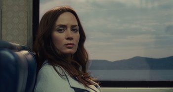 Movie still from “The Girl on the Train” (2016), directed by Tate Taylor – A woman with long red hair is standing in front of a body of water; Close Up shot, Low angle