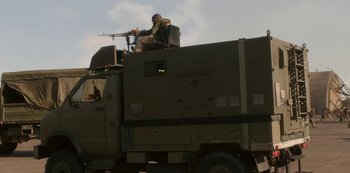 Movie still from “The Girl with All the Gifts” (2016), directed by Colm McCarthy – A man sitting on the hood of a military truck; Wide shot, Low angle