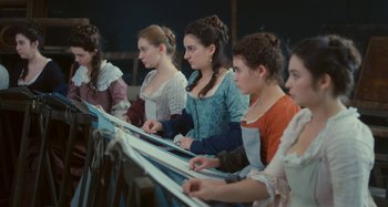 Movie still from “Portrait of a Lady on Fire” (2019), directed by Céline Sciamma – A group of young women sitting next to each other; Medium shot, High angle